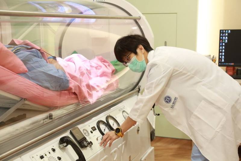 1名男子因一氧化碳中毒就醫，出院後罹患遲發性神經病變，喪失生活自理能力，童綜合醫院高壓氧中心主任吳繼瑩（右）表示，男子經高壓氧治療後康復。圖為病人接受高壓氧治療示意。（童綜合醫院提供）