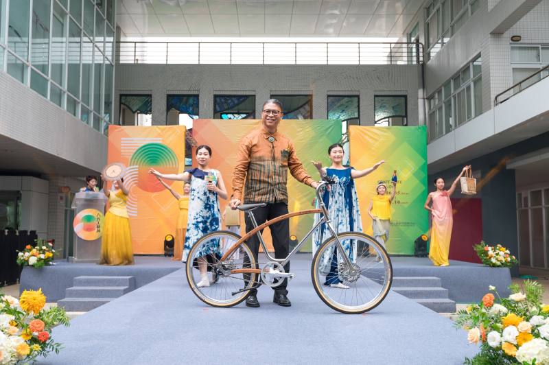 工藝中心主任陳殿禮(中)在開幕儀式中搭配由工藝中心研創作品-木工藝自行車一起走秀出場，並透過倡議「活工藝・工藝活」，落實生活中使用及運用工藝，激發工藝的新生命，讓工藝價值與精神真正深入人心。