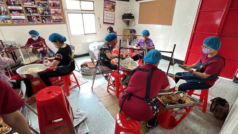 往年台東縣永安村聖安宮在端午節會發放粽子給低收入戶和獨居老人，113年擴大發放全村，每戶都有10顆。圖為7日婆婆媽媽們分工開始包粽子。