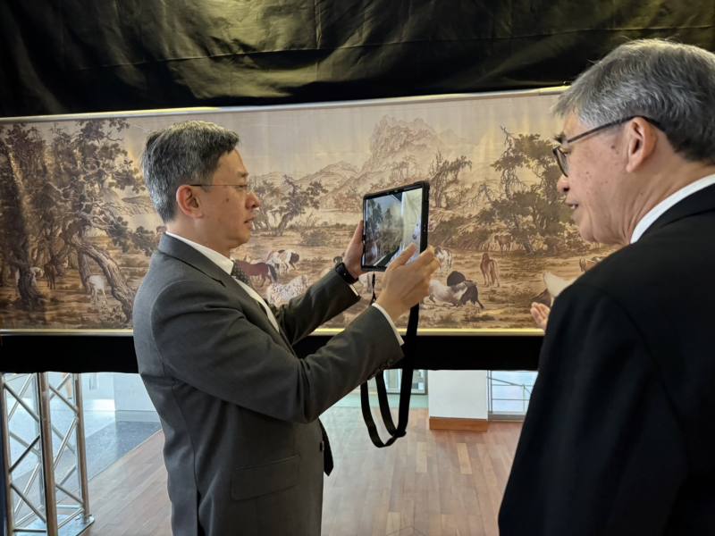 故宮黃永泰副院長(右)向駐歐盟暨比利時李淳大使(左)介紹「透視百駿」擴充實境(AR)互動裝置