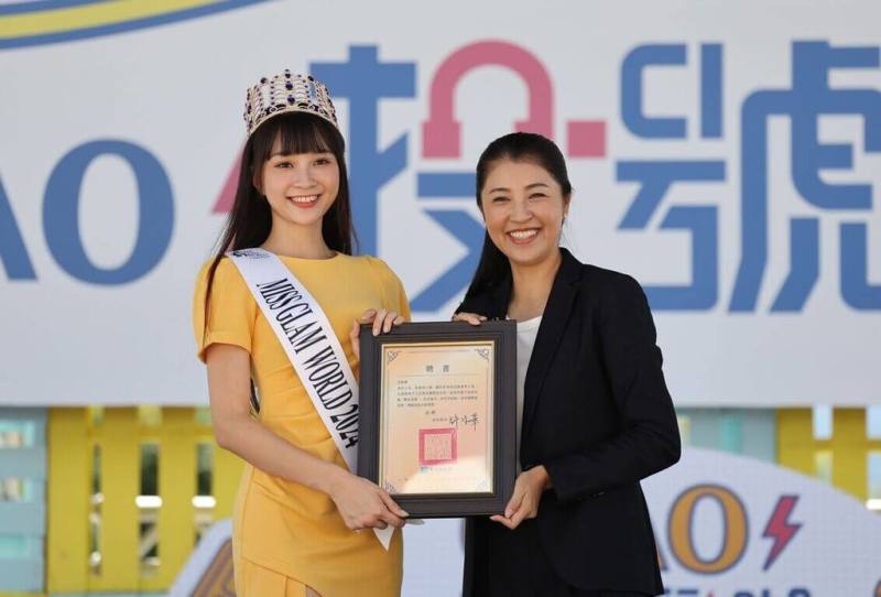 出身南投埔里的中華職棒中信兄弟啦啦隊成員高曼容（左）日前摘下個人首座選美世界冠軍，她15日獲聘為「終身南投縣親善大使」，由南投縣長許淑華（右）頒發聘書。（南投縣政府提供）