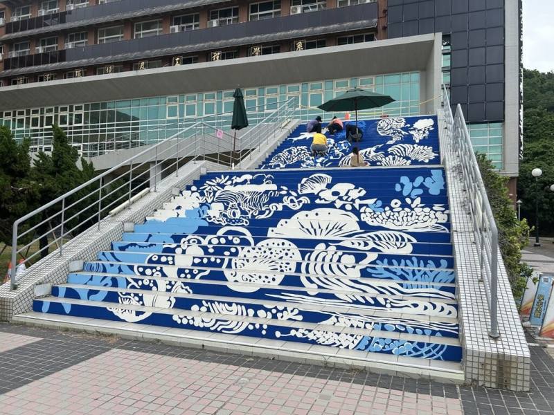 國立中山大學建築綜合大樓靠近海邊，海洋科學院與西灣學院5月號召師生，將戶外正立面階梯彩繪上海洋圖像，盼喚起大家對海洋保育的重視。（中山大學提供）