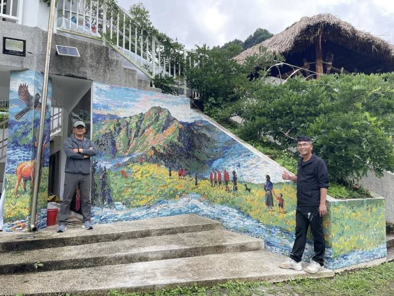 嘉義縣阿里山鄉達邦國小鄒族神話藝術牆近日完工，藝術家歐志成（左）與工作團隊耗時1個月的時間，以馬賽克創作拼貼完成。右為達邦國小校長林進富。（歐志成提供）