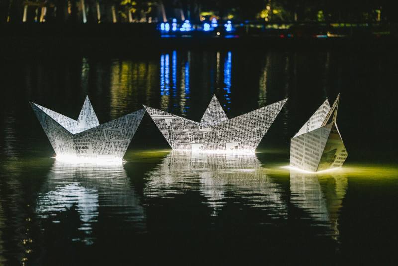 故宮博物院南部院區28日晚間啟動「水樂之夜」，3艘放大版舊報紙摺紙船作為水上裝置藝術呈現，記載著故宮落腳台灣的重大時間點，為2025年故宮百年院慶暖身。（故宮南院提供）