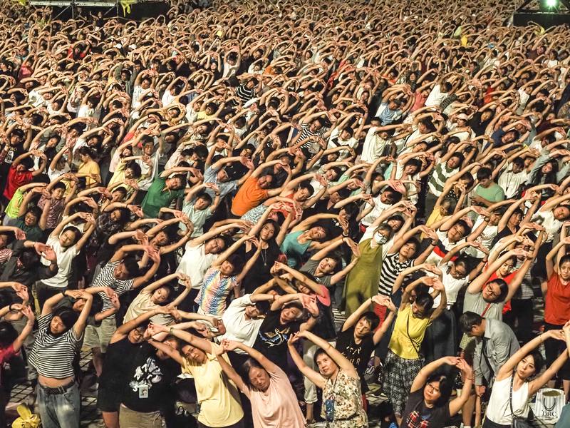 雲門舞集戶外公演邁入第29年，2024年將帶來藝術總監鄭宗龍與日本新媒體藝術家真鍋大度合作的「波」，雲門歷年在每場戶外演出前也會舉辦「全民律動」，帶領觀眾伸展肢體。圖為2019年雲門戶外公演觀眾共同參與活動盛況。（雲門舞集提供，劉振祥攝影）