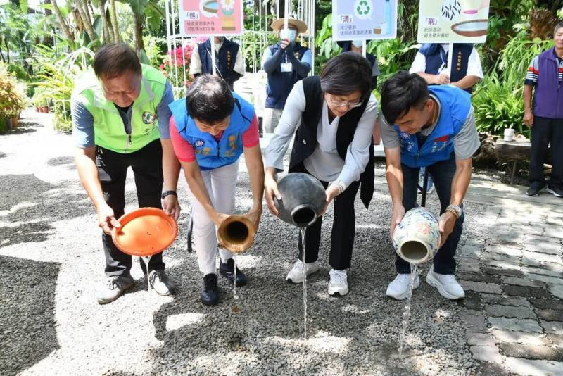 彰化縣政府8日在田尾公路花園舉行登革熱防治宣導記者會，縣長王惠美（前右2）示範清除容器積水，呼籲大家落實居家環境清潔，一起防治登革熱。（彰化縣政府提供）