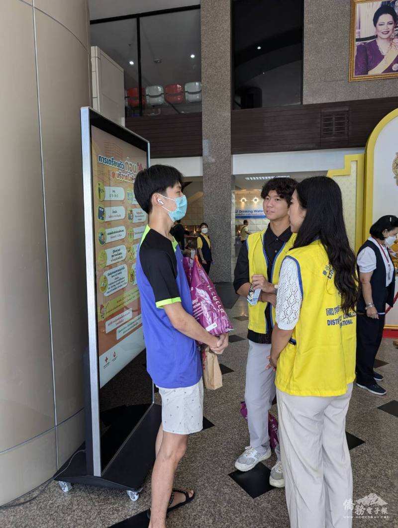 搭僑計畫學員向現場捐血民眾送白米同時行銷臺灣