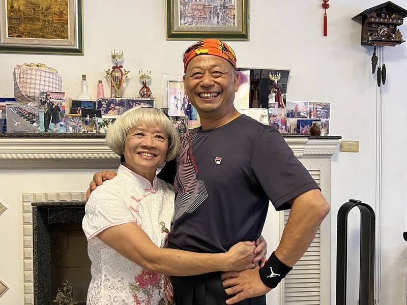 70歲新北市民朱明義（右）獲選民國113年新北市模範父親，他初中畢業後開啟「黑手」人生並創立修車廠養活一家子，目前則開心享受快意人生，陸續考取救生員及街頭藝人證照，他9日也感性向妻子周一好（左）表示，「辛苦妳了」。