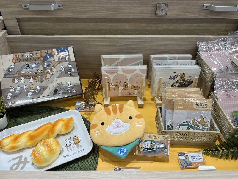 高雄捷運左營站「蜜柑站長專賣店」13日開幕，店內除有明信片、紙膠帶、購物袋、鑰匙圈等文創商品外，也與在地店家共同推出果醬、餅乾等伴手禮。