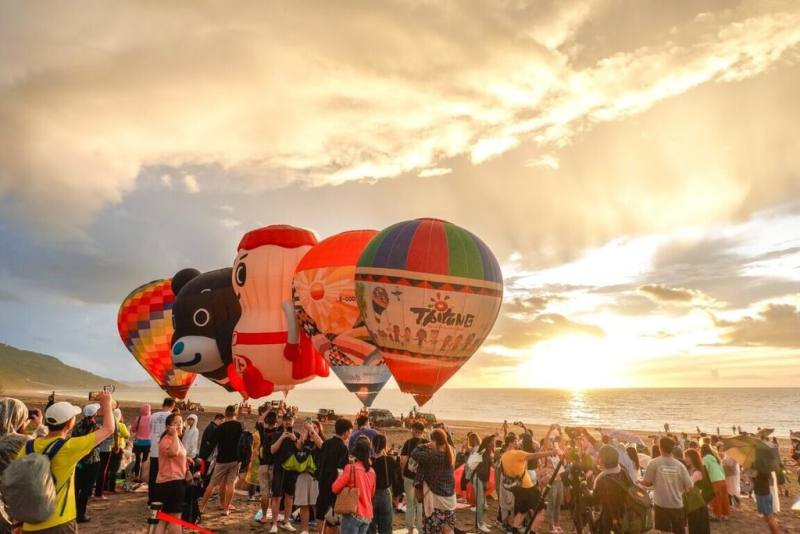 台東太麻里曙光園區15日舉辦熱氣球嘉年華光雕音樂會，當繽紛熱氣球豎起，搭配主題音樂，民眾紛紛拿起手機拍照，捕捉精彩畫面。（台東縣政府提供）