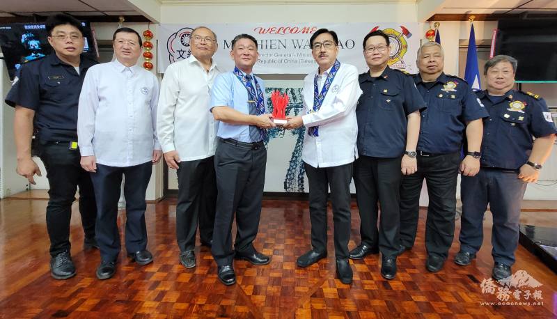 簡萬瑤（左4）贈送紀念品予菲華文經總會，並由吳治平（右4）代表接受