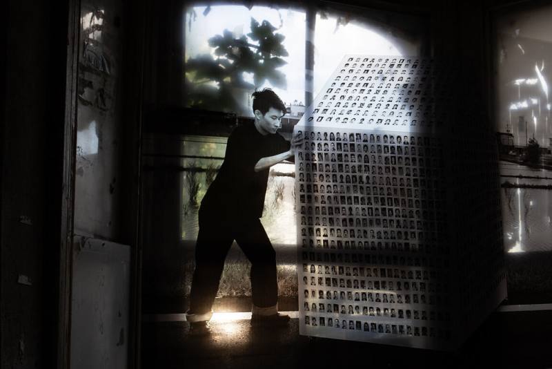 藝術家莊智皓將作品房子上貼滿了家族中每位成員的照片，影片紀錄了他將房子從新家推往舊家的過程，就如同他在回溯自己的身份。（莊智皓提供）