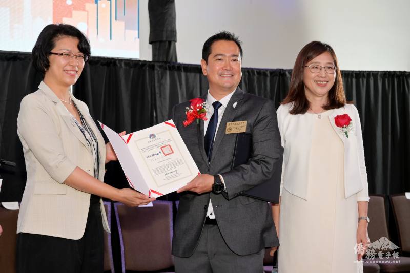 駐休士頓辦事處處長蕭伊芳（左）代表僑委會頒發新會長賀狀給新任會長蔣佑邦（中）