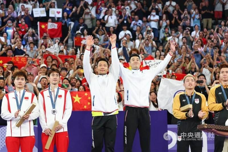 Taiwanese badminton players Lee Yang (third left) and Wang Chi-lin (fourth left) celebrate their gold medal win on the podium at the Paris Olympics on Sunday. CNA photo Aug. 4, 2024