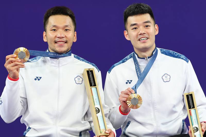 台灣羽球黃金男雙組合「麟洋配」李洋（左）、王齊麟（右）再次攜手征戰奧運殿堂，法國時間4日下午在2024巴黎奧運金牌戰打敗中國組合、順利摘金，兩人頒獎後開心拿著獎牌合影。