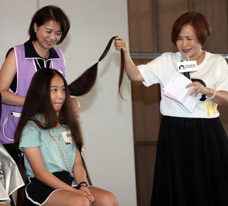 癌症希望基金會募髮行動台北場4日展開，現場99名捐髮者，年紀最小3歲，最大60歲，其中蓄髮9年的「長髮公主」（前左）帶著長度快到大腿的頭髮，毫不猶豫剪去30公分