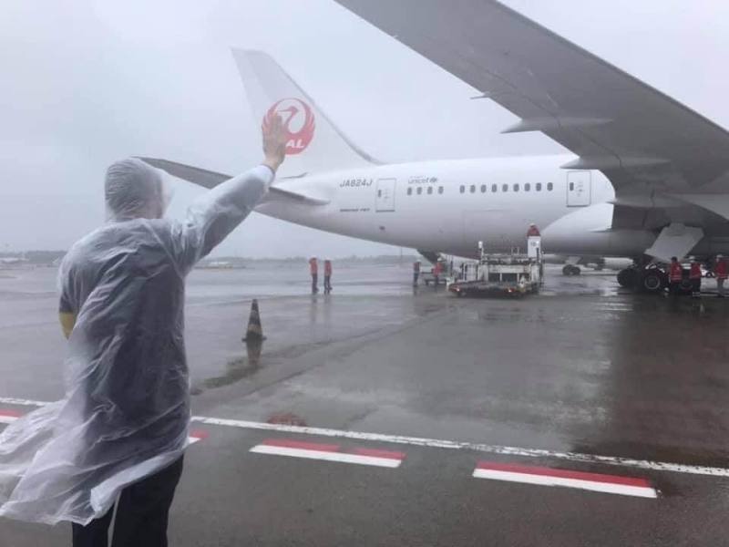 駐日本代表謝長廷結束出使日本8年多的生涯返國。日本2021年6月4日提供124萬劑AZ疫苗給台灣，謝長廷穿著雨衣在風雨中向載運疫苗的飛機揮手並鞠躬致敬成為駐日經典身影。（謝長廷提供）