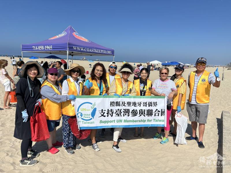 橙縣華人獅子會會長楊怡文（右五）與Team Taiwan召集人張慧玲僑務促進委員（左四）及獅子會會員在淨灘活動入口手持標語