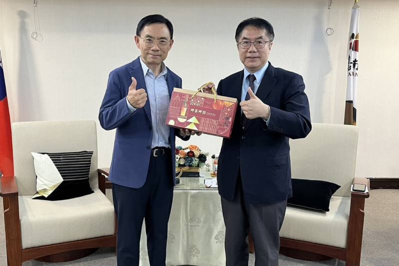 超微（AMD）美國總部資深副總裁王啟尚（左）與台灣分公司團隊代表20日拜訪台南市政府，與市長黃偉哲（右）會面，黃偉哲贈送伴手禮。（台南市政府提供）