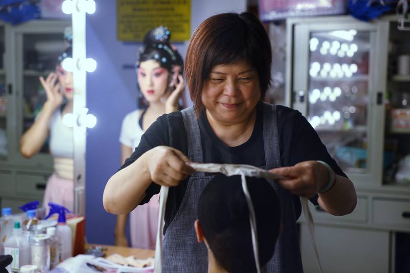 國光劇團箱管組組長、負責包頭容妝的張美芳（前）表示，專門替京劇旦角打造頸部以上造型的「包頭桌」，功夫並不容易，光最基礎的打片子（假髮）就得苦練個3、5年