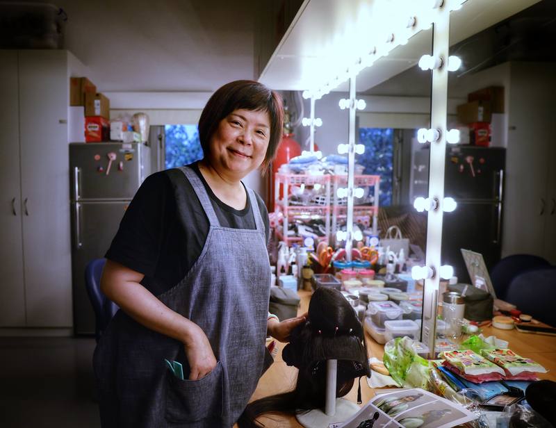 國光劇團箱管組組長、負責包頭容妝的張美芳站在劇場後台30年，管理著有如戲班命脈的重要「戲箱」，圍裙還插著隨時替演員調整頭髮的梳子，成為演員們最安心的存在
