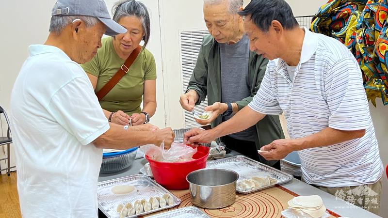 周仙海(左一)等波士頓榮光會員一起包餃子