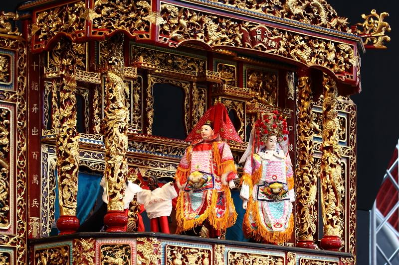 台北木偶劇團於8月6日至8日巴黎奧運期間，在台灣館展現台灣布袋戲簡史，圖為劇中媽祖遶境現場，小小戲台裡有著大型神將與小型遶境人員