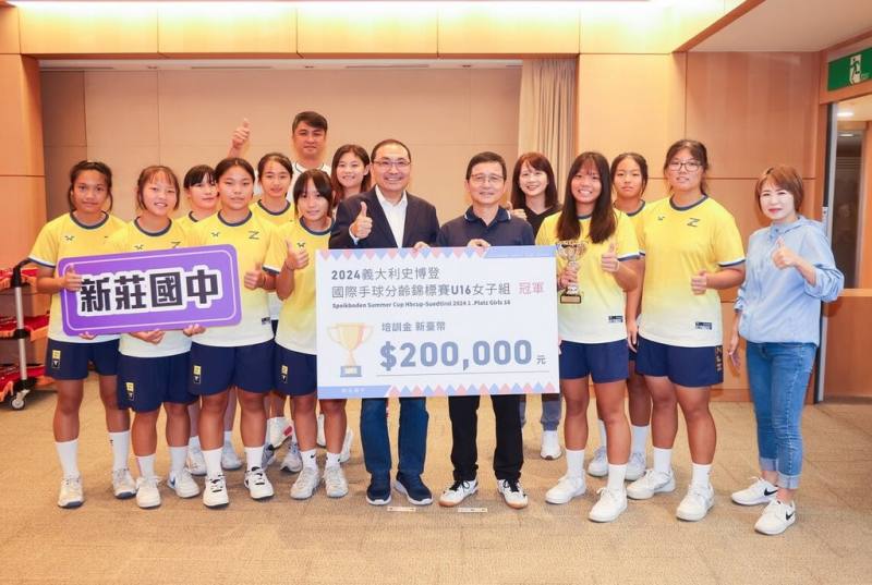 新北市新莊國中女子手球隊拿下「2024年第34屆義大利史博登國際手球分齡賽」U16組冠軍，4日到市政會議分享喜悅，市長侯友宜（前右5）頒發培訓金給予鼓勵。（新北體育局提供）