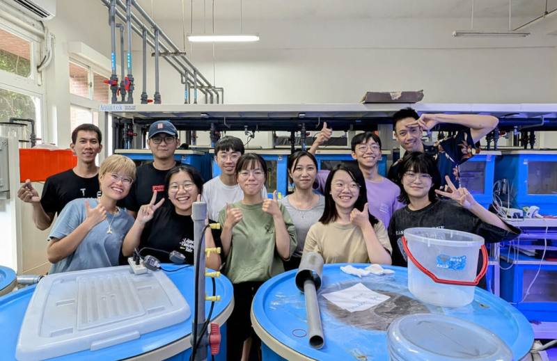 國立中山大學海洋生物科技暨資源學系副教授王亮鈞（後右1）創設全亞洲唯一海洋及致病微生物實驗室，實驗室團隊研究魚皮膚、共生菌及環境的三角關係，首度發現魚皮黏膜上的共生菌具抵抗力與治癒力，可幫助魚類抵擋環境中病菌，有利存活。（中山大學提供）