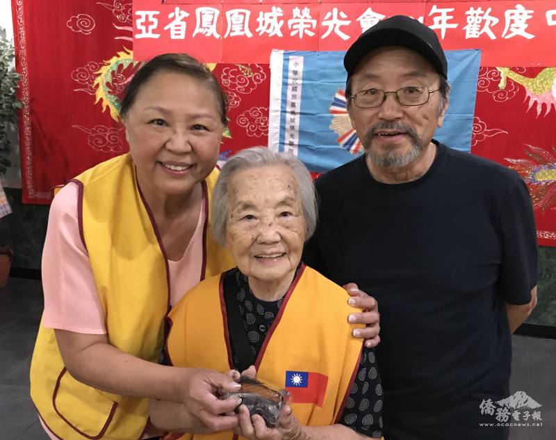 王瑞瑾(左)贈月餅給「鳳凰城榮光會」之寶、97歲的張秀蘭(中)致意，右為姜立群