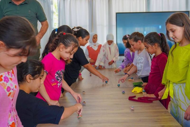 台北科技大學團隊與土耳其台灣中心合作，為敘利亞難民兒童規劃木育課程，帶領孩子們製作陀螺。（北科大提供）
