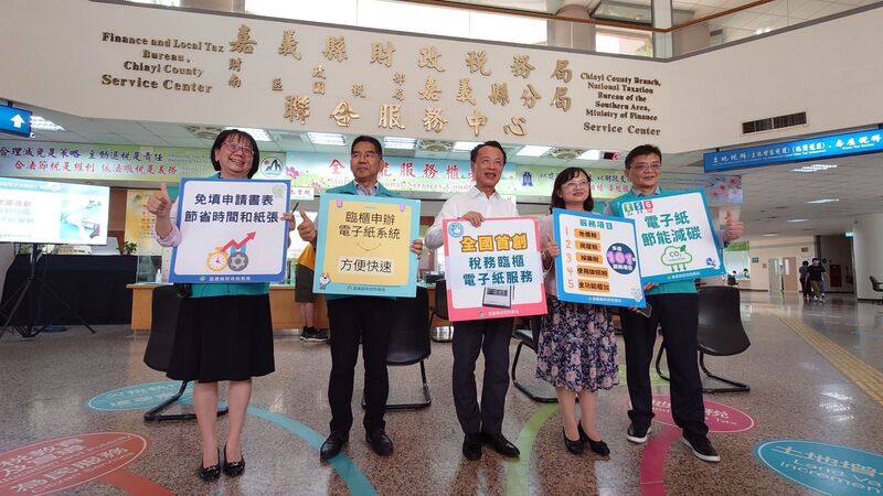 嘉義縣財政稅務局使用「臨櫃申辦無紙化運用電子紙系統」，縣長翁章梁（中）29日表示，無紙化系統結合電子紙低碳技術，實現了年省數萬張紙張的目標，未來縣府將持續推動更多智慧化與友善性的政策與服務，讓嘉義縣成為更具智慧、更加宜居的地方