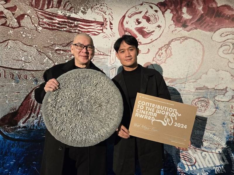 Taiwan-based Malaysian film director Tsai Ming-liang (left) on Saturday displays his Contribution to World Cinema Award from the Ji.hlava International Documentary Film Festival alongside actor Anong Houngheuangsy, the lead of Tsai's feature "Where." Phot
