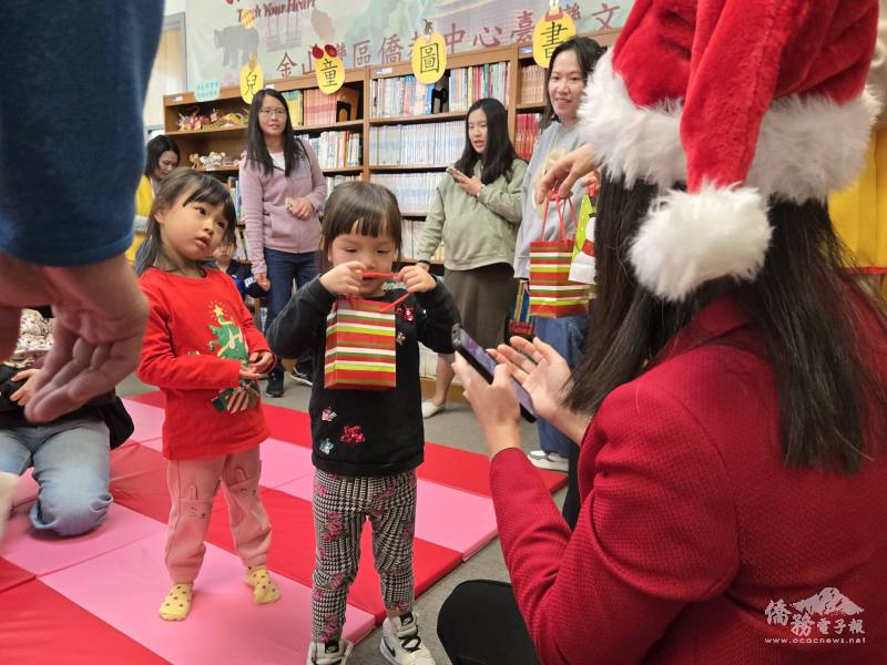 莊雅淑變身為聖誕老婆婆，親切向孩童發送節日禮物，不少僑青家庭為了應景也穿上聖誕節氣氛服飾