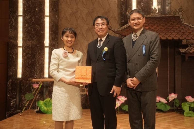 台南市長黃偉哲（中）10日率團參加東京花道博覽會，致贈日本首相石破茂夫人佳子（左）台南的蘭花絲巾。右為自然屋物產株式会社暨台灣自然屋董事長陳俊雄。（台南市政府提供）