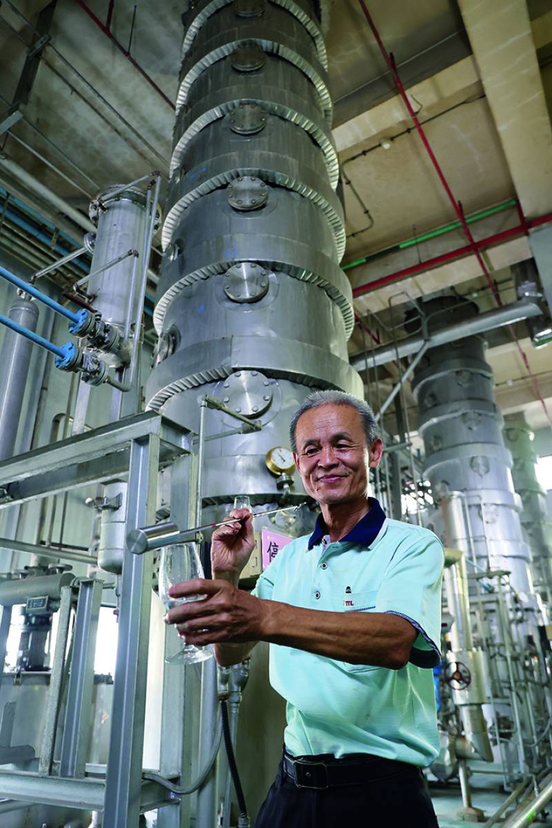 A TTLC staffer draws some freshly distilled rice wine from an industrial still. Its aroma is especially rich and heady. ​​