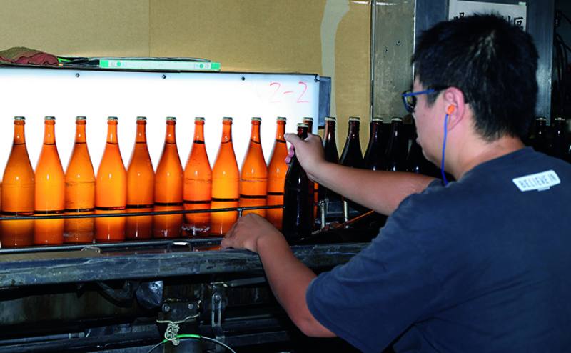 Just-bottled rice wine awaits labeling before shipping.​​