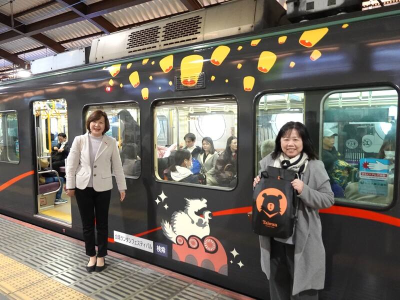 日本神奈川縣電車「江之島電鐵」因有著名動畫「灌籃高手」的平交道經典場景，吸引大批朝聖人潮。交通部觀光署為宣傳2025台灣燈會，也推出江之電「嗶嗶嗶嗶！台灣燈會號」彩繪列車，盼招攬更多遊客訪台。圖左為駐日橫濱分處處長張淑玲