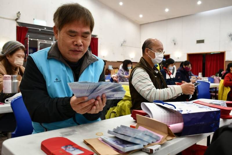 彰化市公所16日發放春節敬老禮金給70歲以上長者，公所員工及志工在彰化市介壽藝文館清點現鈔，裝入紅包袋，希望讓長者在過年前領到紅包，開心過好年。（彰化市公所提供）