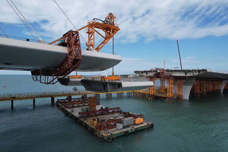 淡江大橋是連接淡水與八里重要交通樞紐，由世界知名建築師札哈．哈蒂（Zaha Hadid）設計，主橋段長920公尺，橋塔高211.4公尺。圖為懸臂工作車吊裝5T鋼節塊。(中央社提供)