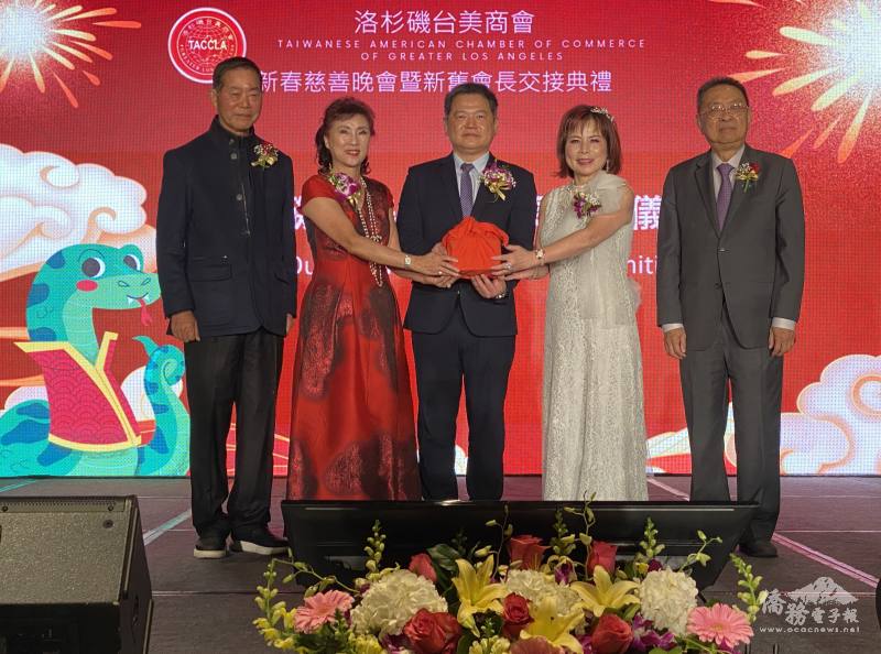 在駐洛杉磯辦事處長紀欽耀(中)、國策顧問楊信(左1)與田詒鴻(右1)的監交下，由滿任會長葉怡蘭(左2)交接印信予新任會長陳玲華(右2)