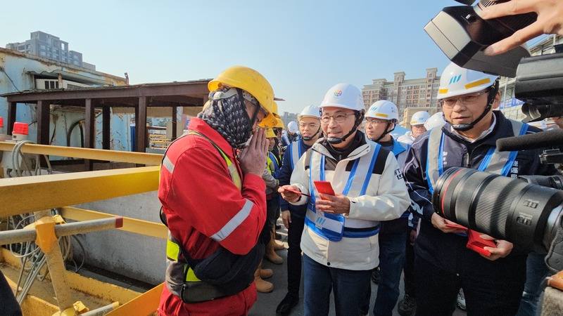 新北市長侯友宜（前右2）21日到蘆洲視察捷運環狀線北環段機廠工程，現場發放紅包，預祝施工團隊新年快樂。(中央社提供)