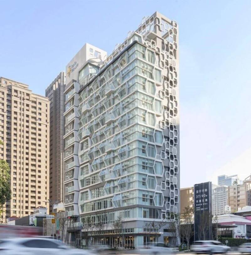 長榮集團在台中新推出的品牌飯店「采．寓halo house」，外觀採獨特的六角形玻璃帷幕設計，內部巧妙融合涵洞及圓弧造型，呼應鄰近的國家歌劇院特色，完美結合藝術與現代建築，為台中再添亮眼特色建築。（長榮集團提供）