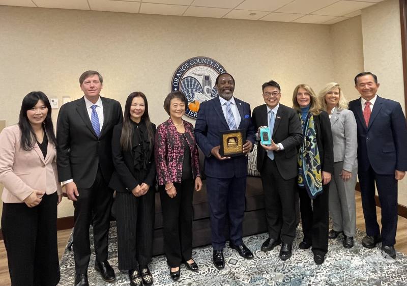 駐邁阿密辦事處處長周啟宇率領奧蘭多臺僑領袖拜訪橘郡郡長戴明斯，並致贈「一帆風順」黃金畫