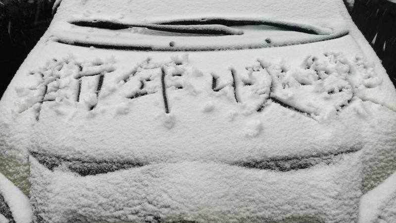 受寒流影響，宜蘭太平山國家森林遊樂區27日清晨降下冰霰，遊客們開心在車蓋寫下「新年快樂」。（農業部林業及自然保育署宜蘭分署提供）