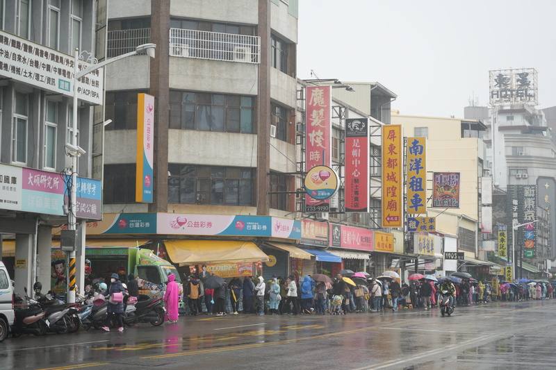 屏東市都城隍廟財神1日發錢母，廟方準備1萬2000份，排隊民眾雨中熱情不減，綿延數公里。