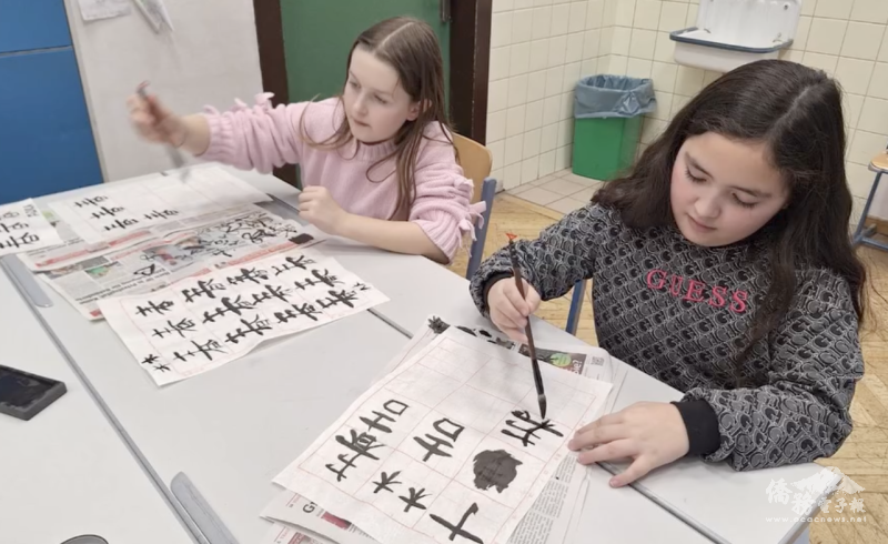 孩子們專注地練習毛筆字，一筆一劃臨摹老師示範的字體。即使是初次接觸書法，他們依然充滿興趣，全神貫注地認真練習