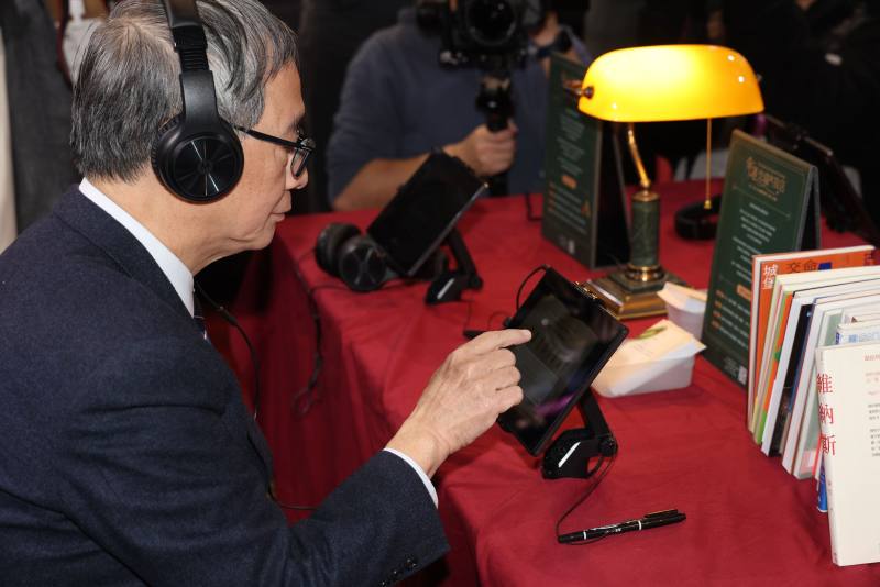 文化部長李遠於台北國際書展數位主題館「命運交織的旅店」體驗裝置互動。