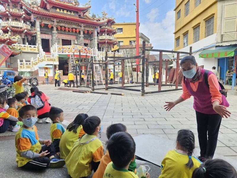 屏東縣佳冬鄉六根村三山國王廟7日搭建福廠，實施沉浸式客語教育的佳冬鄉立幼兒園師生也到場觀賞了解、傳承客家文化。（民眾提供）