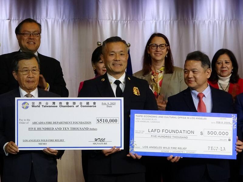 駐洛杉磯台北經濟文化辦事處長紀欽耀（右）、世界台灣商會聯合總會會長吳光宜（左）分別秀出50萬美元的捐款支票，支持洛杉磯野火受災區域重建。阿凱迪亞消防局長孫振傑（中）代表接受